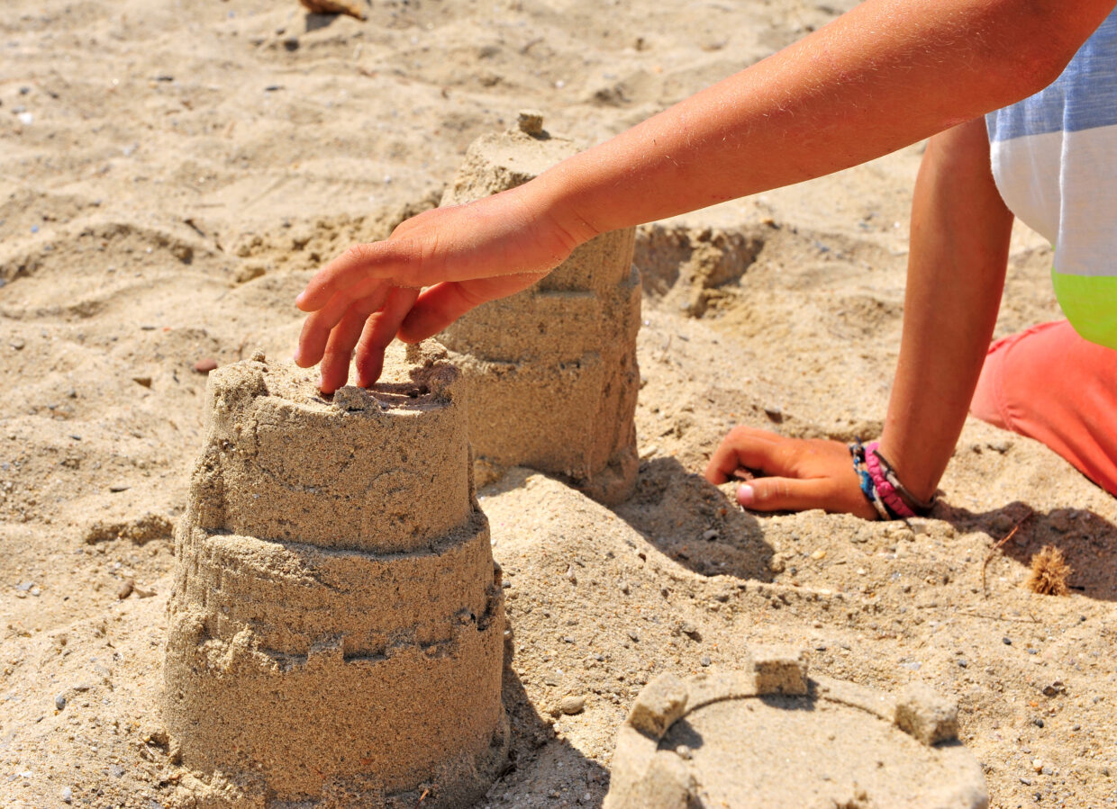 Little boy building a castle on beach